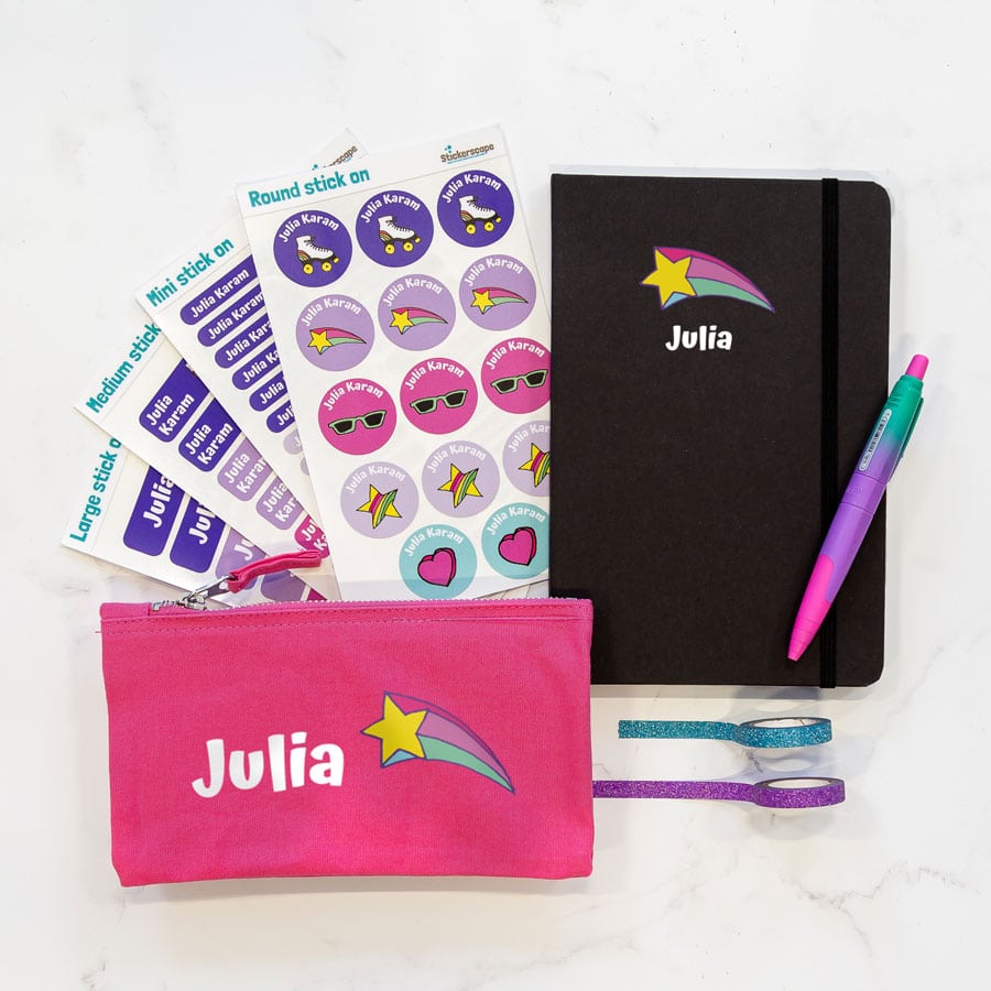 Mega Retro doodles back to school bundle featuring a black notebook, a pink pencil case and four sheets of stick on name labels. With the name Julia in white with a pink yellow and blue shooting star.