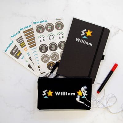 Gaming back to school mega bundle. Includes four sheets of stick on name labels, a black notebook with the name william in silver text below images of a silver lightening bolt, a yellow star and blue triangle, a black pencil case with the name in silver in-between two sets of silver lightening bolts, yellow stars and blue triangles.