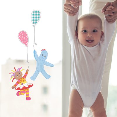 Igglepiggle and Upsy Daisy With Balloons window sticker shown on a window behind a happy baby