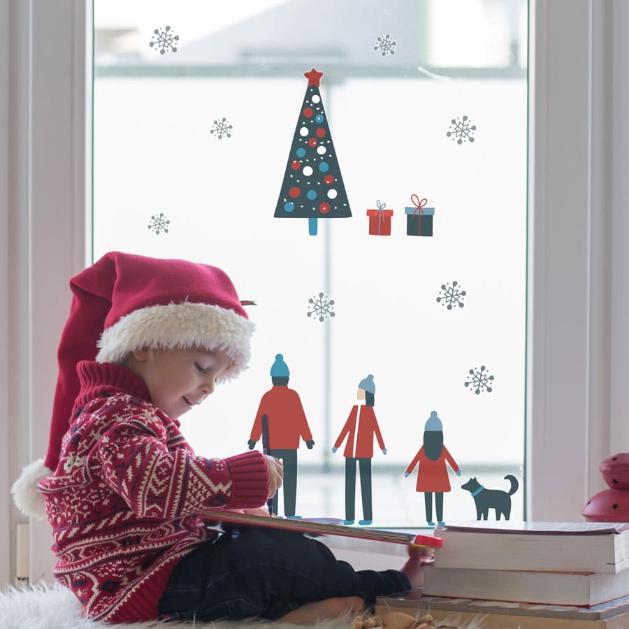 Scandi family winter scene window stickers decorating a window with child in santa hat
