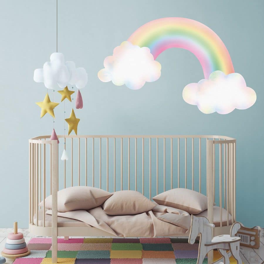 pastel rainbow with clouds wall sticker above a cot on a blue grey wall