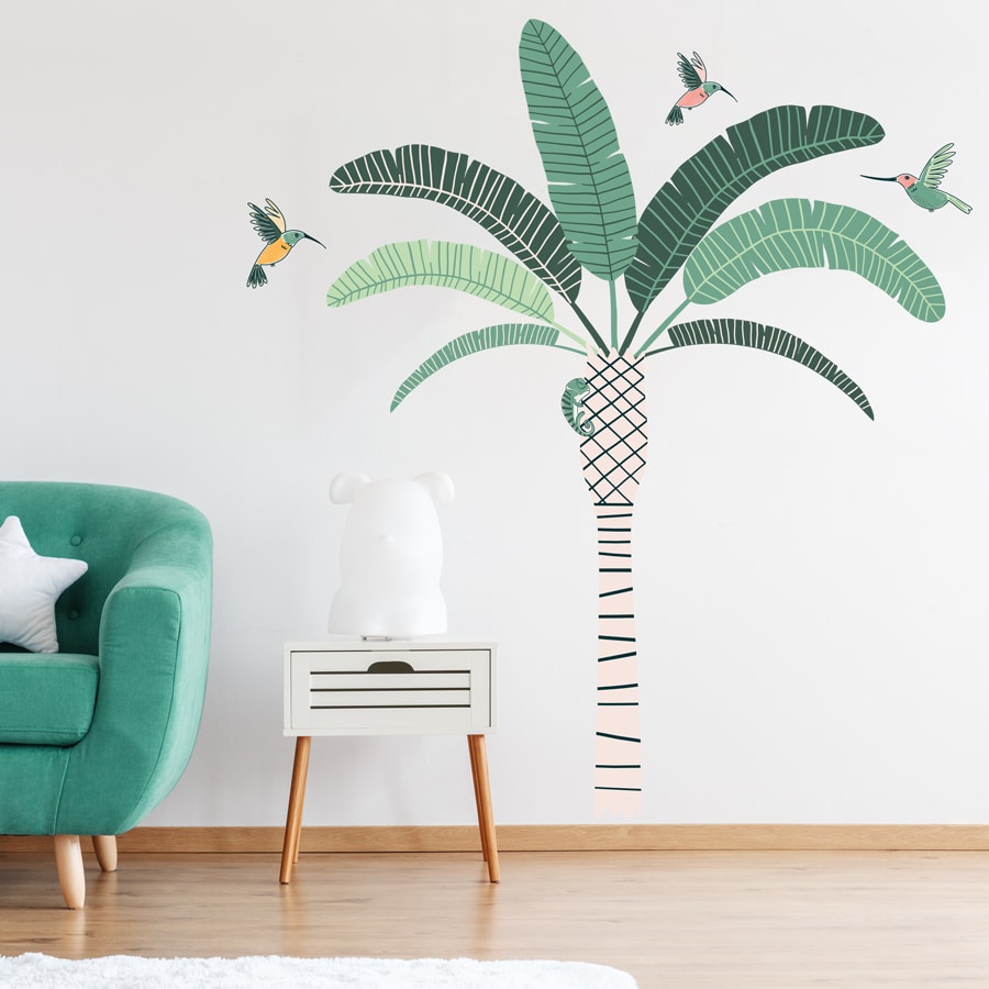 Tropical Palm Tree Wall Sticker Jungle wall sticker. Image showing a room with a green sofa and a stripy palm tree with green leaves and green and pink hummingbirds stickers on the wall.