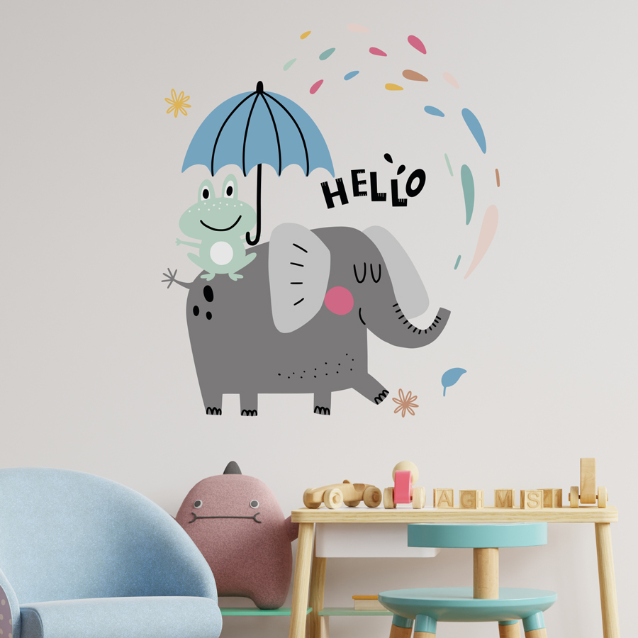 Fun elephant wall sticker large on a light beige wall, above a wooden table and blue and pink plush chairs