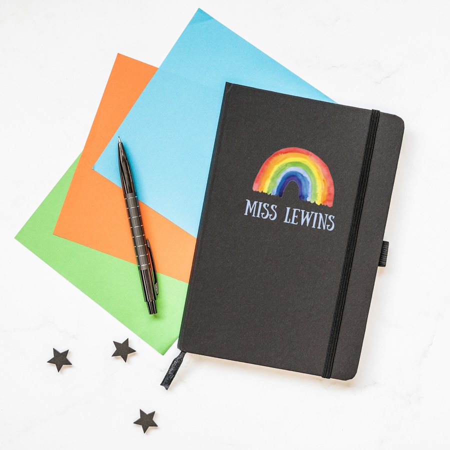 Personalised rainbow notebook in black features a rainbow design with personalised name underneath and is a perfect gift for a teacher or teaching assistant to say thank you