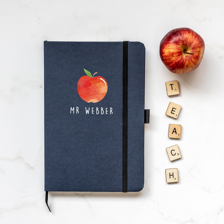 Personalised apple notebook in blue features a rainbow design with personalised name underneath and is a perfect gift for a teacher or teaching assistant to say thank you