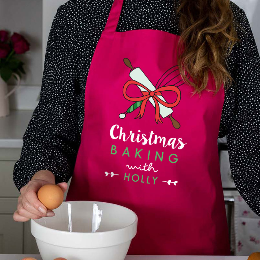 Christmas Baking with apron in pink featuring whisk and rolling pin