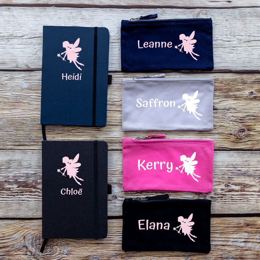 Colour options for fairies back to school bundles. Blue/Black notebook with pink fairy in centre top with name text below in pink. Navy/grey/pink/black pencil case with pink fairy on right with pink name text on left.