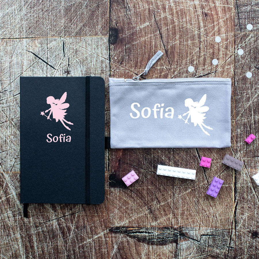 Fairies back to school mini bundles. Black notebook with pink fairy in centre top with name text below in pink. Grey pencil case with pink fairy on right with pink name text on left.