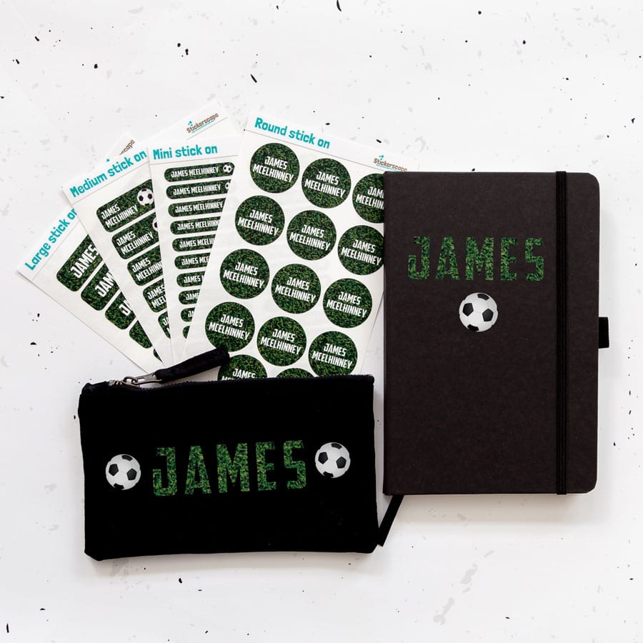 Mega back to school bundle. Black pencil case, black notebook and four sheets of name labels featuring the name James in a grass print with footballs.