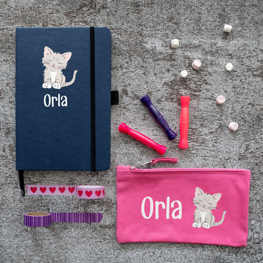 cat back to school mini bundles. blue notebook with cat illustration in centre with name text in white underneath. pink pencil case with image of cat in centre with name text in white to the left.