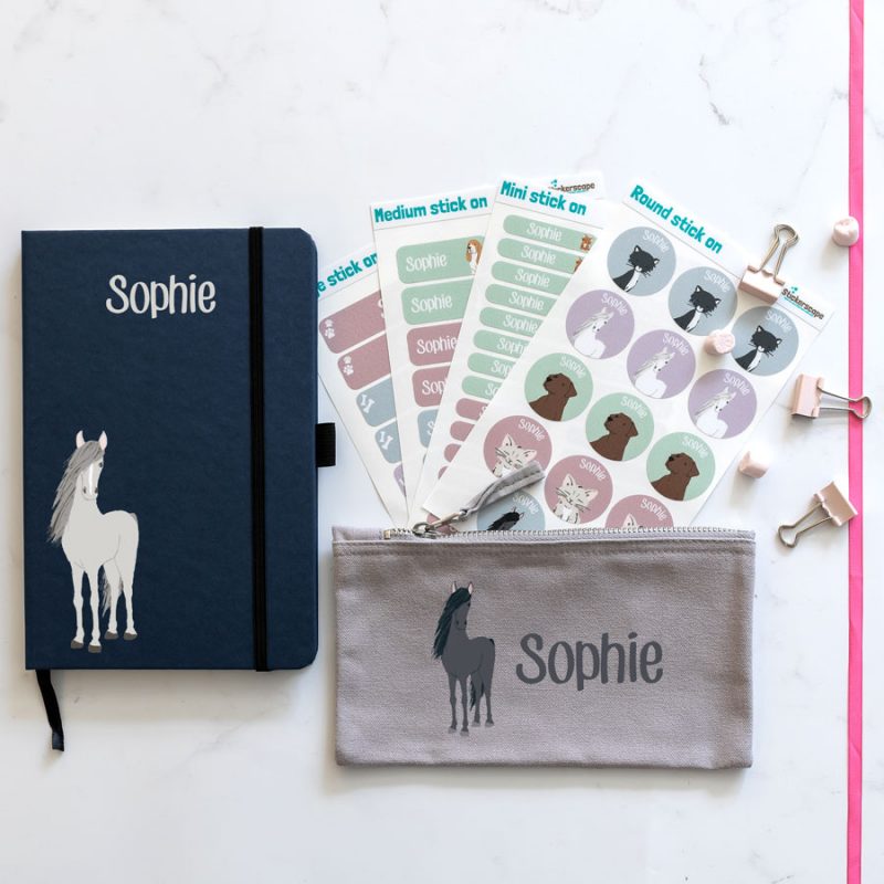 Horse back to school mega bundles. blue notebook with horse illustration bottom left with name text in white at top centre. grey pencil case with image of horse on left with name text in white to the right. 4 sheets of stick on name labels.