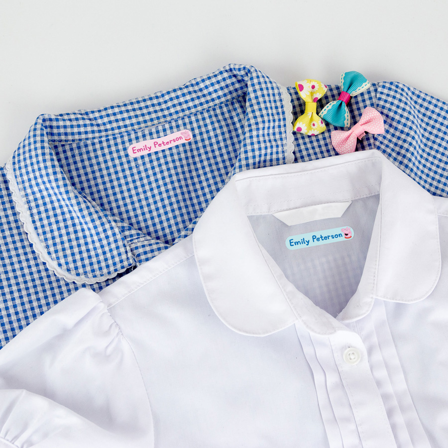 Peppa pig iron on name labels shown attached to a blue checked dress and a white shirt