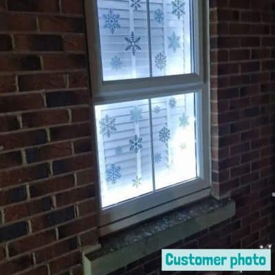snowflake window stickers (blue and grey) on a customer's window from the outside