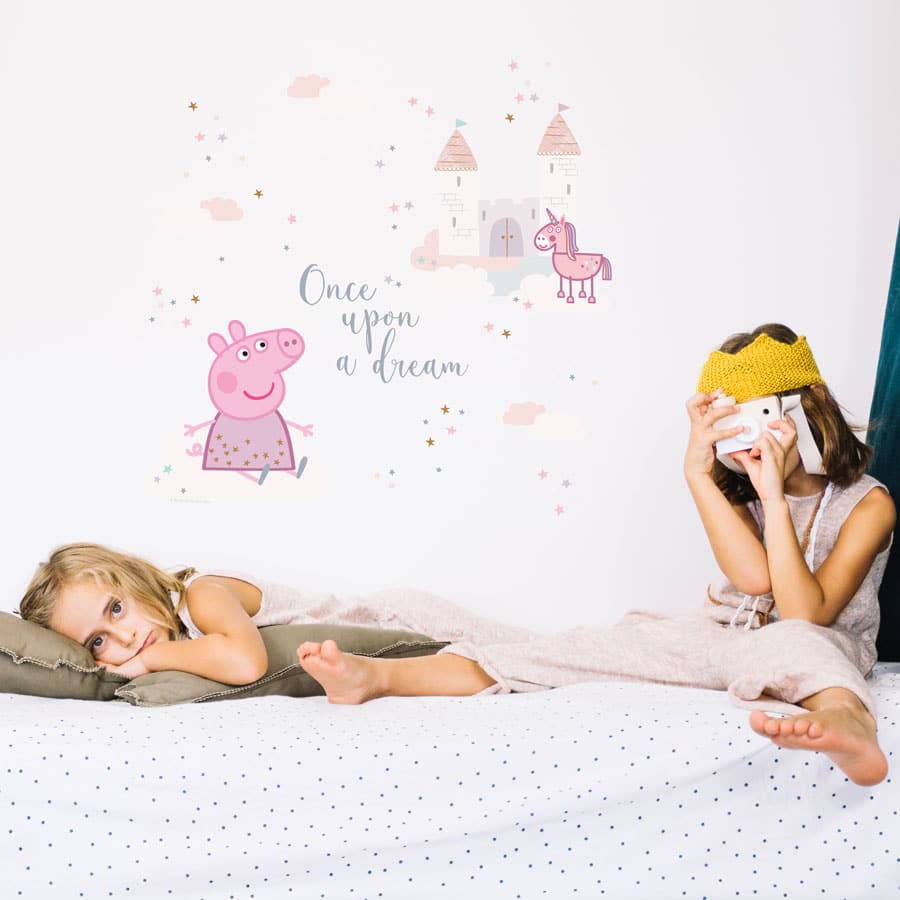 once upon a time Peppa pig wall sticker shown on a white wall behind two girls on a bed