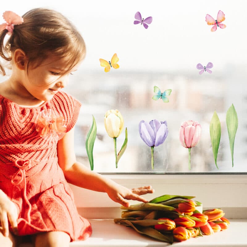 tulip window stickers with a child creating a spring themed window display