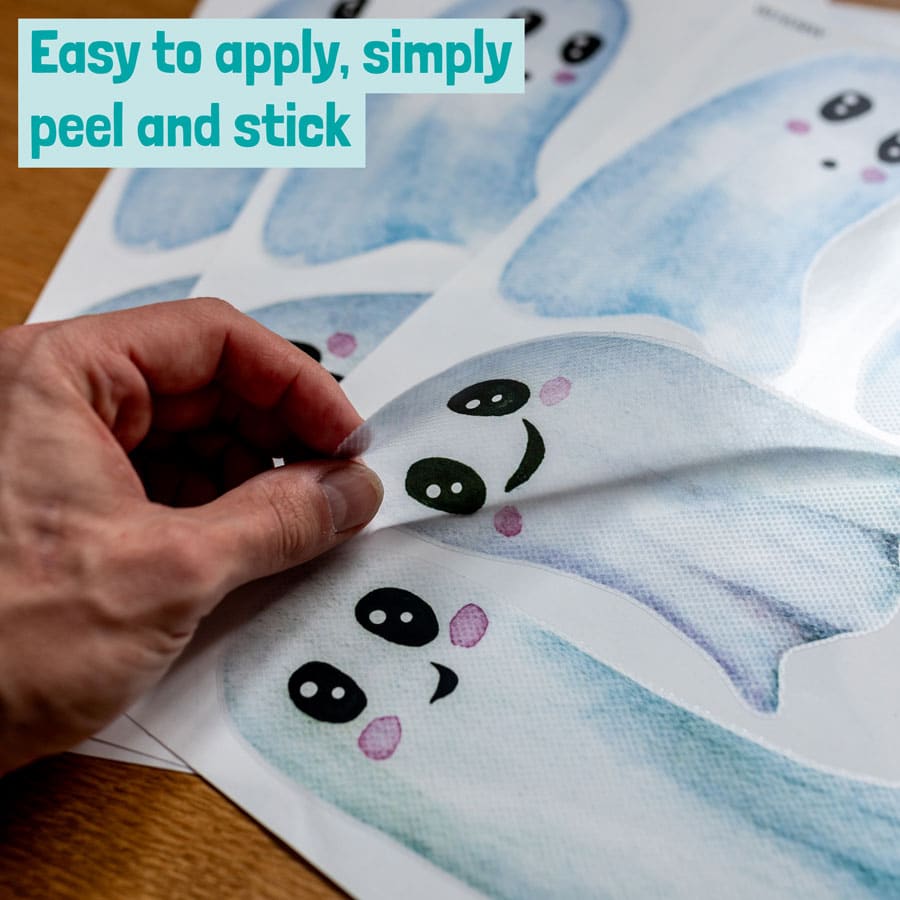 cute white ghost window stickers being removed from backing sheet