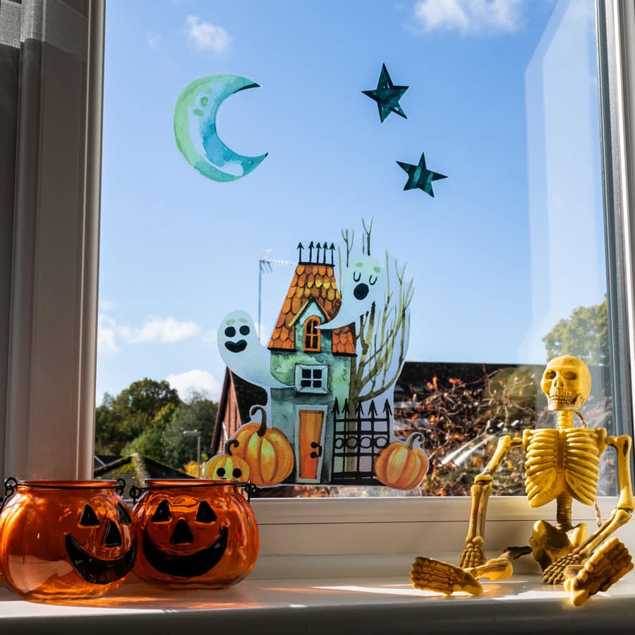 Haunted House Window Sticker with pumpkin and a skeleton on a sunny day