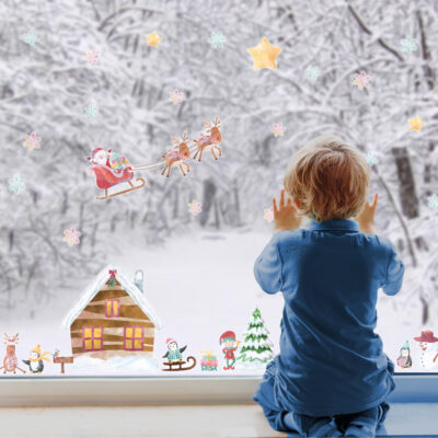 North Pole Christmas Window Stickers (Regular size) on a window with child featuring Santa, Snowflakes and other festive elements