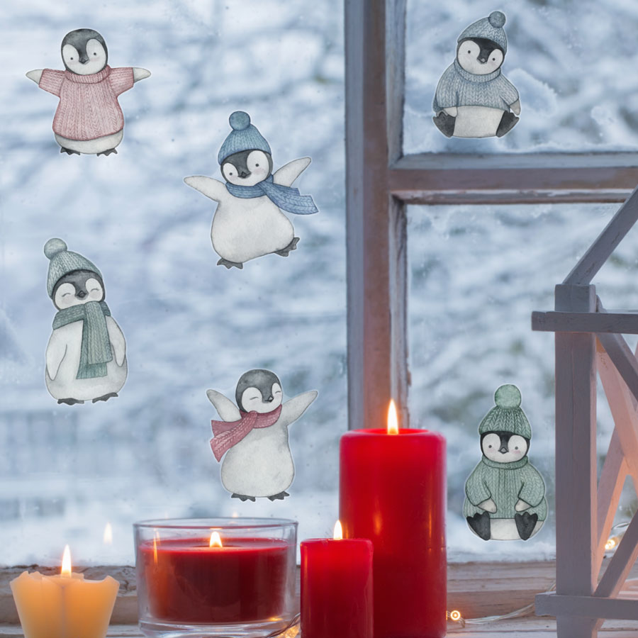 Watercolour Penguin Window Stickers on a window with red candle in front