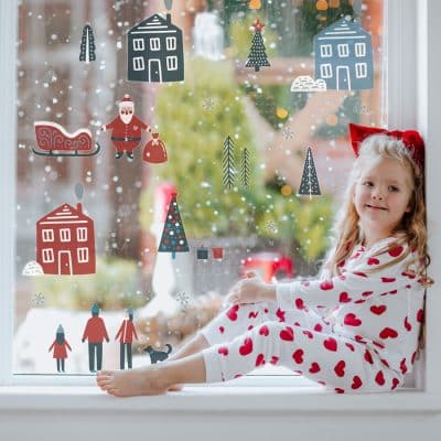 scandi christmas window stickers on a window with child sitting on window sill
