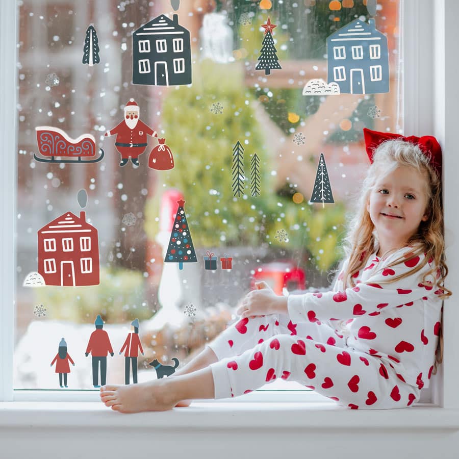 scandi christmas window stickers on a window with child sitting on window sill