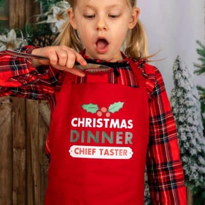 Personalised Christmas Dinner apron with junior red apron a child pretending to taste food