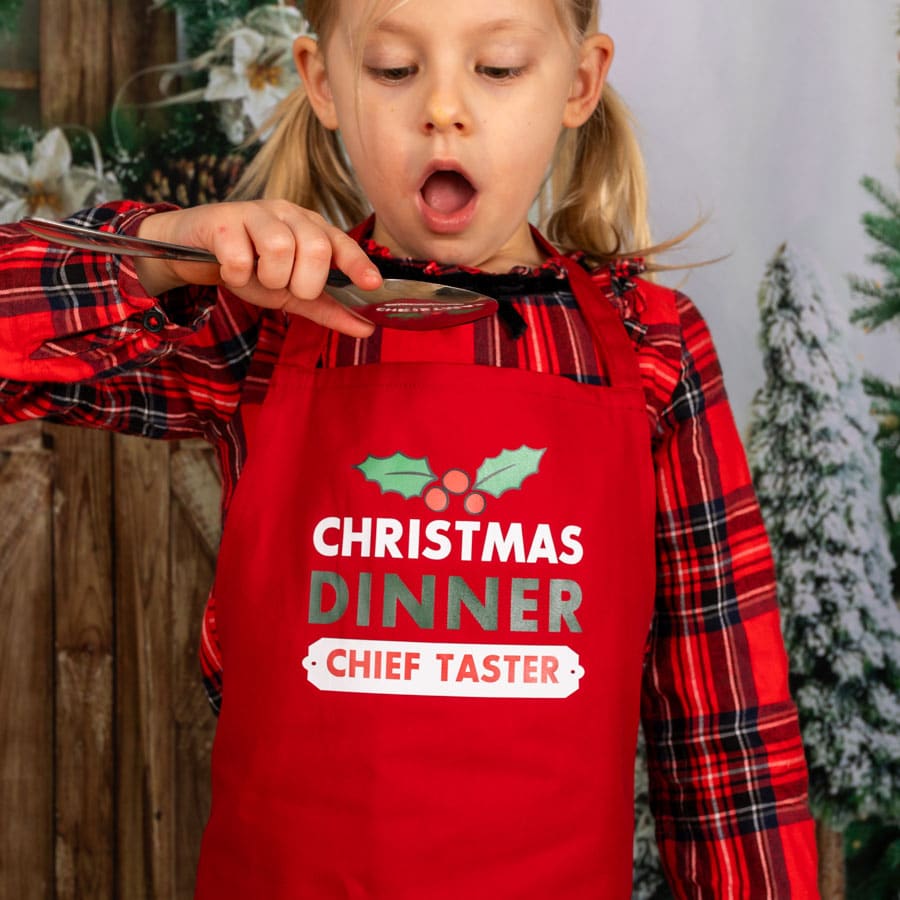 Personalised Christmas Dinner apron with junior red apron a child pretending to taste food