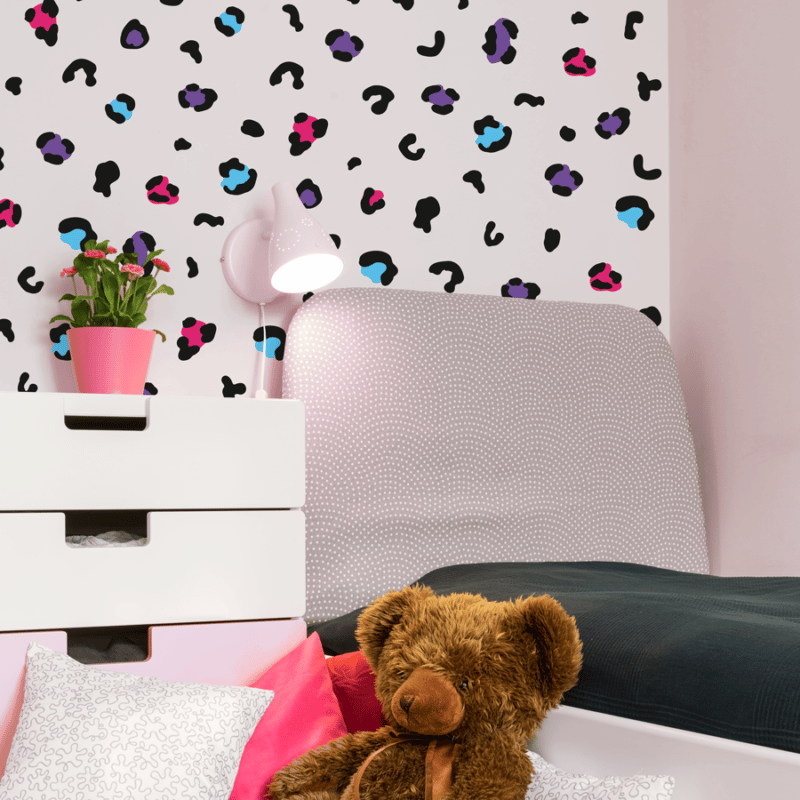 Colourful leopard print wall stickers in black and neon shown in a childs bedroom on a white wall