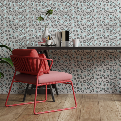 Two tone leopard print wall sticker tile in black and blue shown on a white wall behind a black desk and red chair