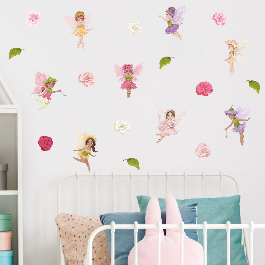 Whimsical fairies wall sticker pack in regular shown on white wall behind a white bedframe with blue and pink pillows