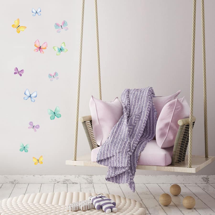 Butterfly wall sticker pack shown on a white wall behind a lilac swing