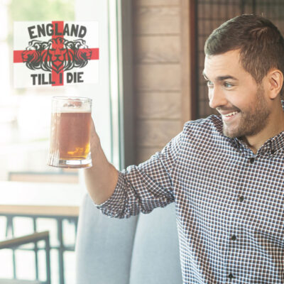 England till I die window sticker in regular shown on the indie of a pub window behind a man holding a pint of beer