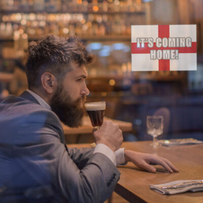 It's coming home window sticker option 1 shown on a window in front of a man drinking a beer