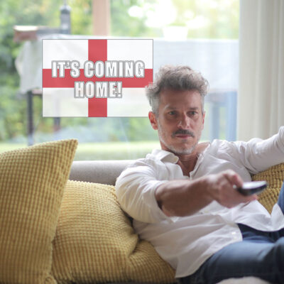 It's coming home window sticker option 1 shown on a window behind a man sat on a sofa
