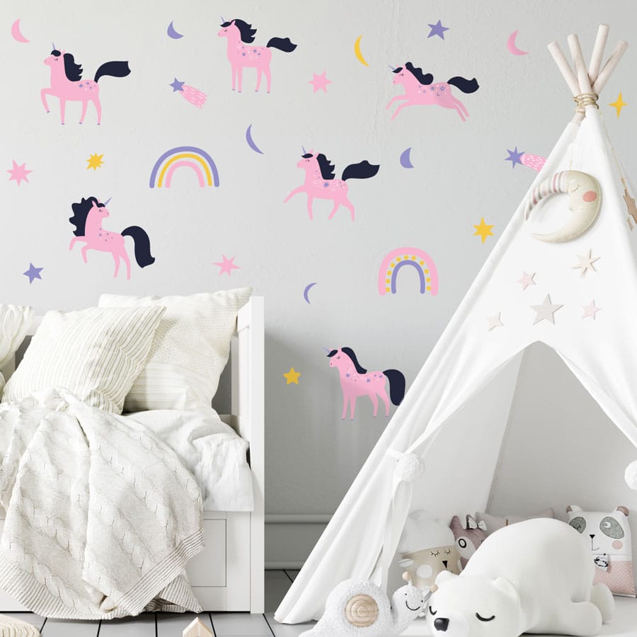purple & pink unicorn wall sticker pack in large shown on a white wall behind a white bed and teepee