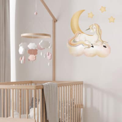 sleepy unicorn wall sticker shown on a white wall behind a wooden cot