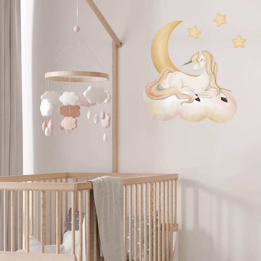 sleepy unicorn wall sticker shown on a white wall behind a wooden cot