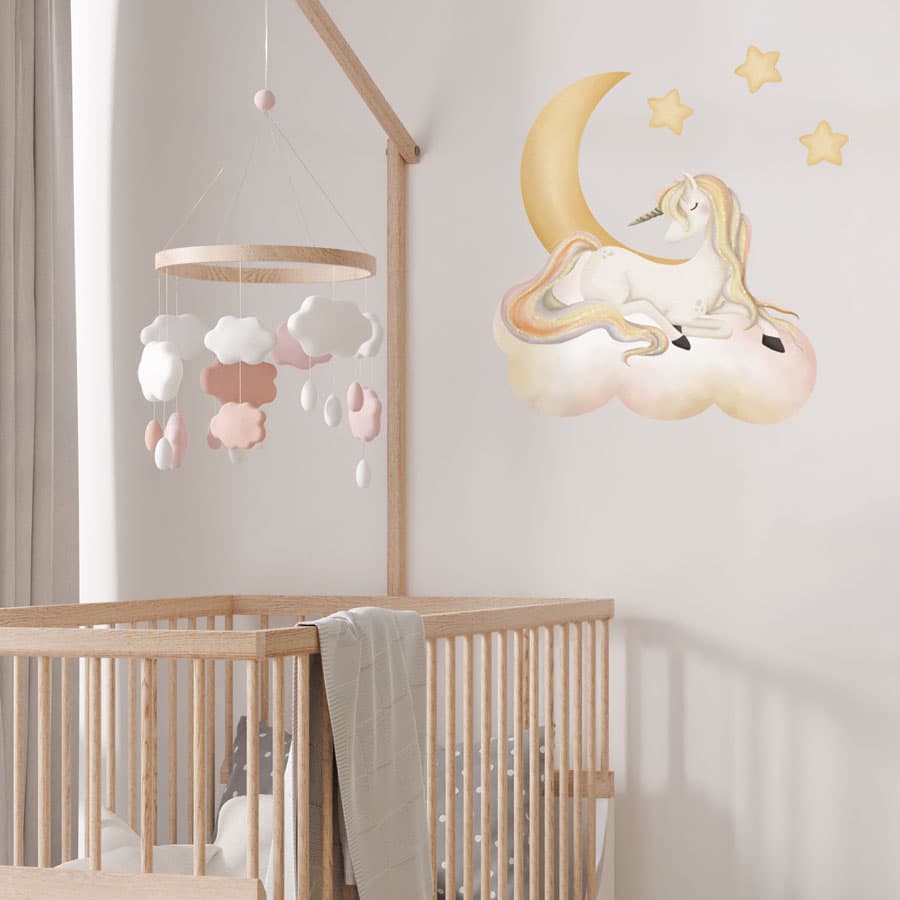 sleepy unicorn wall sticker shown on a white wall behind a wooden cot