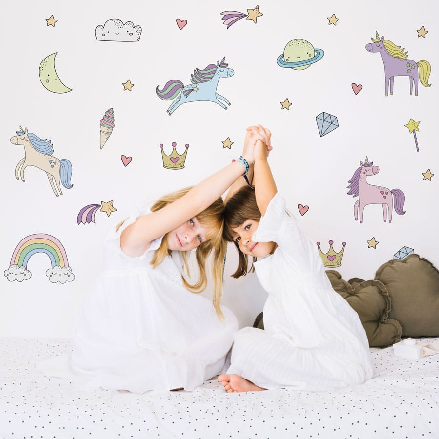 Colour-in Unicorn Wall Sticker Pack shown on a white wall behind a white bed