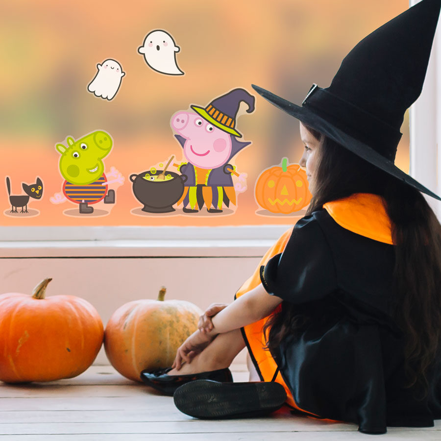 peppa & george halloween window sticker shown on a window behind a young girl dressed as a witch with two pumpkins