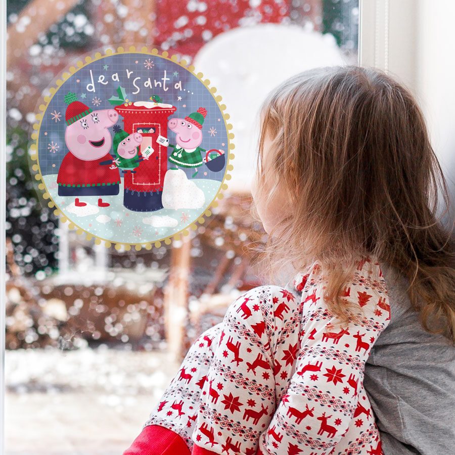 peppa christmas postbox window sticker regular shown on a window behind a young girl