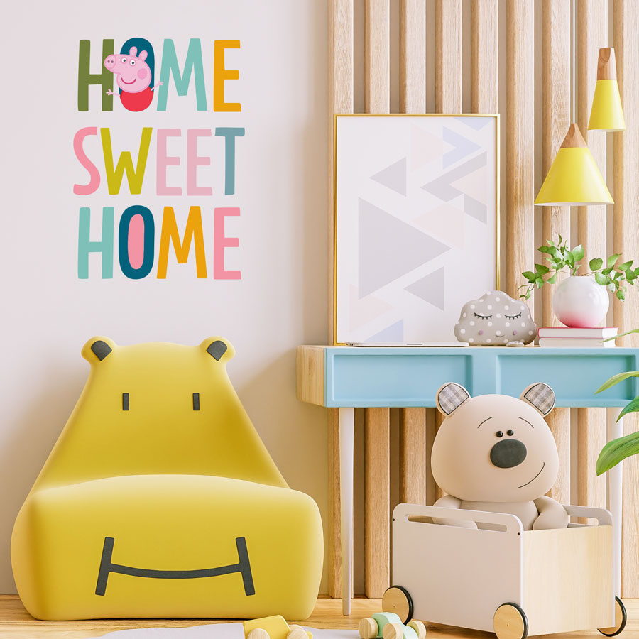 home sweet home wall sticker, peppa pig wall sticker shown on a cream coloured wall next to a wooden wall display behind a yellow chair