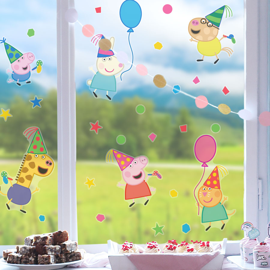 Peppa pig party window stickers regular shown on a window behind a table of cake
