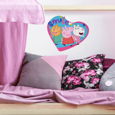 peppa and friends smile wall sticker shown on a white wall behind a pink and grey bed set