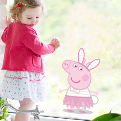 peppa pig easter window sticker shown on a window behind a small girl