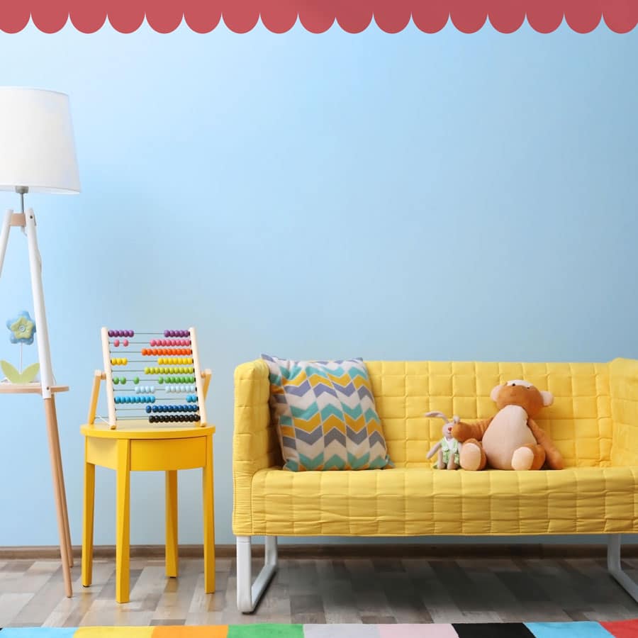 scallop wall stickers in pink shown on a light blue wall above a yellow sofa