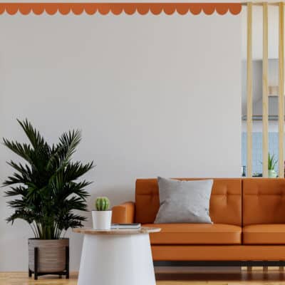 scallop wall stickers in terracotta shown on a white wall above a matching sofa