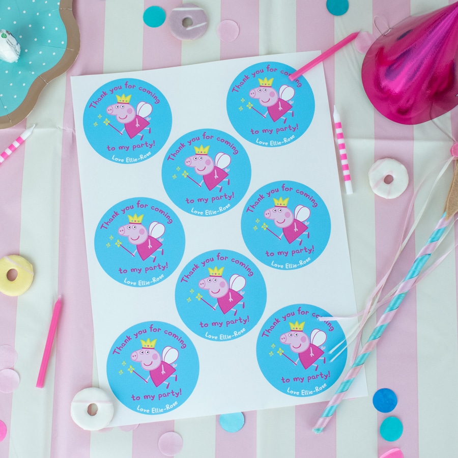 personalised fairy peppa party label pack shown on the sheet on top of a pink striped table cover