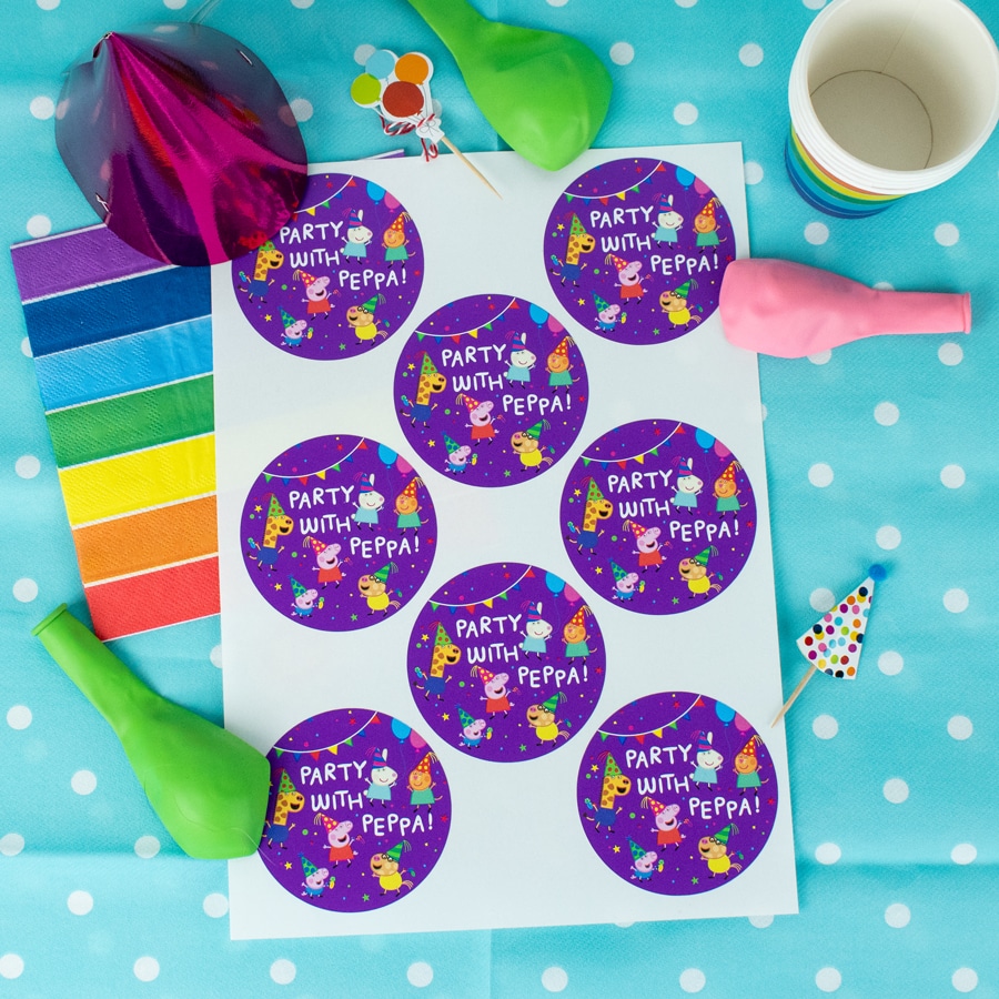 Peppa pig party bag label pack in purple shown on the sheet on top a blue table cover