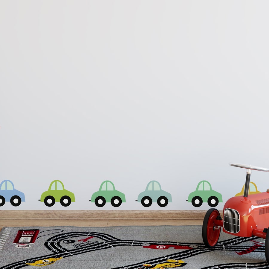 rainbow cars wall sticker pack regular shown on the bottom of a white wall behind a child sized car